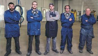 Ford technicians in front of paint booth